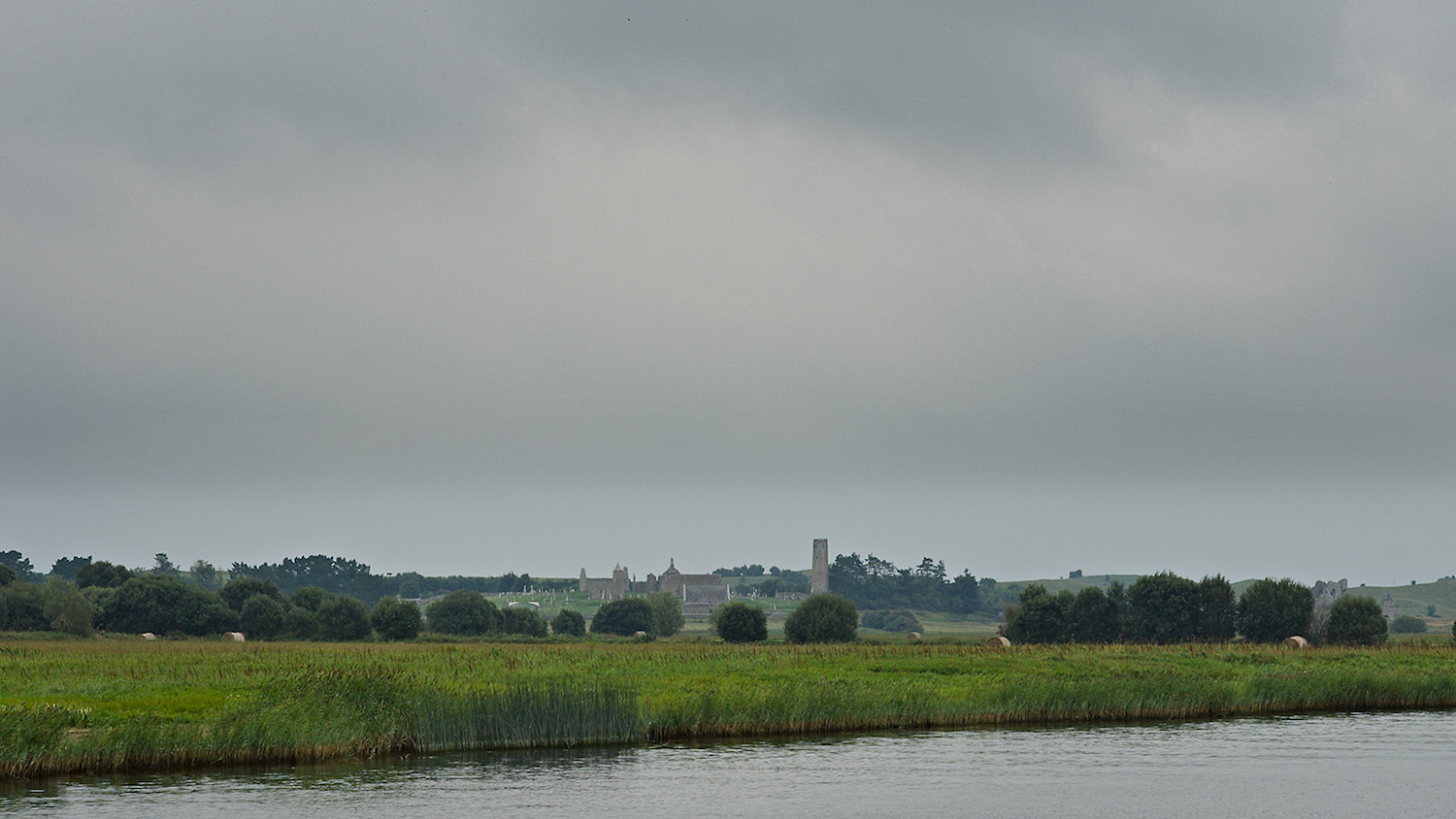 Approaching the ruins of the monastery Clonmacnoise on the river Shannon, County Leinster, Ireland. Tagged with landscape